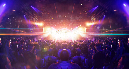 Concert crowd inside a venue, lens flare and smoke are visible.