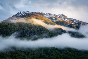 Mountains buried in fog around Lake Bohinj in Slovenia during colorful sunset