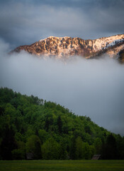 Mountains buried in fog around Lake Bohinj in Slovenia during colorful sunset