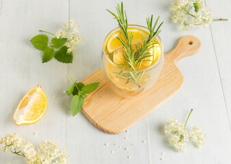 Homemade lemonade with elderberry syrup and rosemary. Close-up, on a light wooden background