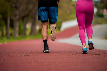 Fototapeta na wymiar Attractive healthy fitness couple running at the stadium