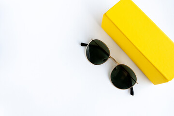 sunglasses on a white background in a yellow case. Place for your text.