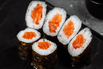 Simple maki with fresh salmon. Sushi on a gray background