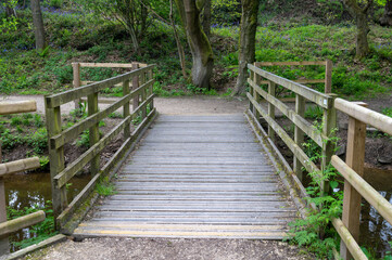 Wooden foot bridge with anti slip strips across a small stream