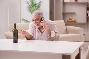 Old man drinking alcohol at home