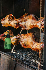 Grilled Two Goats carcasses on spit close-up, food barbecue concept. Selective focus