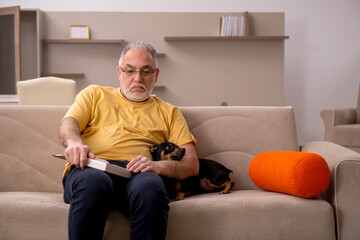 Aged man with little dog at home