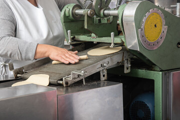 machine to make tortillas Mexican tortilleria with metal band and a kilo of tortillas wrapped in white paper