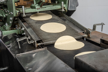 machine to make tortillas Mexican tortilleria with metal band and a kilo of tortillas wrapped in...