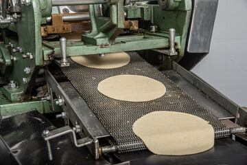 machine to make tortillas Mexican tortilleria with metal band and a kilo of tortillas wrapped in white paper