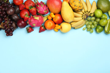 Many different delicious exotic fruits on light blue background, flat lay. Space for text