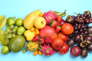 Fototapeta na wymiar Many different delicious exotic fruits on light blue background, flat lay