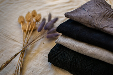gray and black clothes on white canvas with violet and brown decoration branches