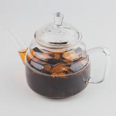 glass teapot filled with pu-erh tea in tangerine