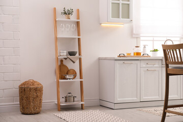 Stylish kitchen room interior with wooden ladder near white wall