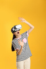 Woman using virtual reality headset on yellow background