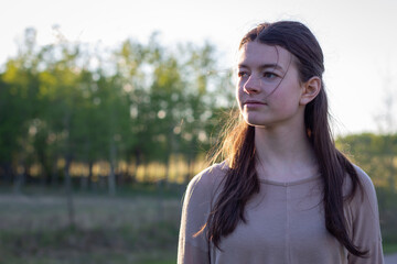 portrait of young woman outdoors at sunset with copy space