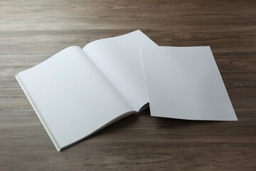 Sheet of paper and blank brochure on wooden table. Mockup for design