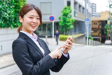 スマホで場所を探す若いビジネスウーマン