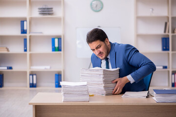 Young male employee unhappy with excessive work in the office