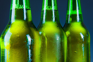 green beer bottle with drops on blue background