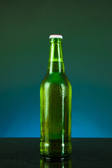 green beer bottle with drops on blue background