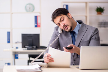 Fototapeta premium Young male employee working in the office