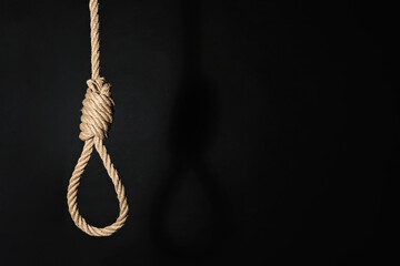 Rope noose with knot on black background, space for text