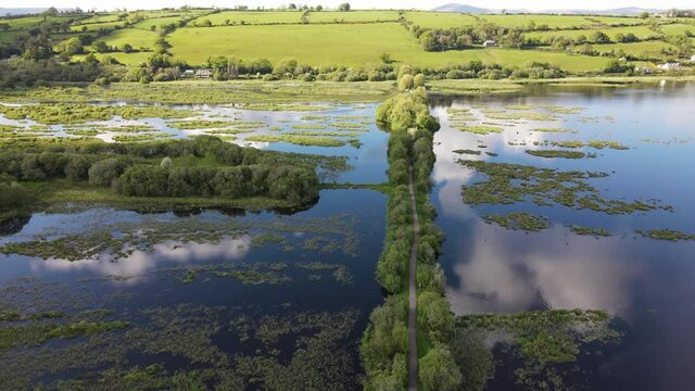 An aerial footage with landing above the footpath on water with cloud reflections on a sunny day
