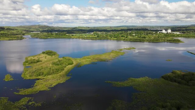 Panoramic aerial footage over river and green hills during high tide, the Gearagh protected nature in county Cork, Ireland.