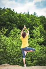 woman doing yoga outdoors in summer