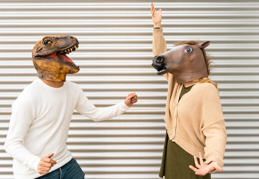Happy couple of man and woman with dinosaur and horse head mask celebrating and dancing.Arm raised up ,positive and success people lifestyle concept with copy space.