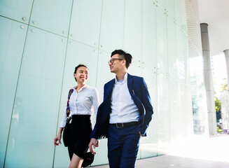 Asian business people in a disussion while walking