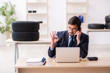 Young man selling tires in the office