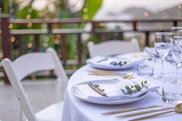 Romantic Wedding Table Top Layout Table Spread no people tropical location with gold cutlery white table cloth and scenic view of sunset with copy space tablescape, beautiful paradise setting