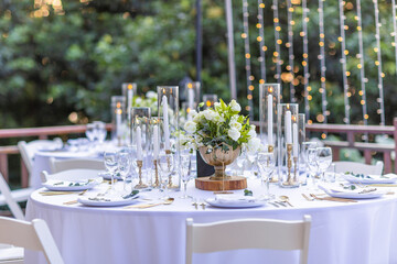 Romantic Wedding Table Top Layout Table Spread no people tropical location with gold cutlery white table cloth and scenic view of sunset with copy space tablescape, beautiful paradise setting