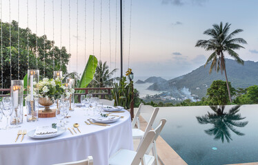 Romantic Wedding Table Top Layout Table Spread no people tropical location with gold cutlery white table cloth and scenic view of sunset with copy space tablescape, beautiful paradise setting