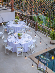 Romantic Wedding Table Top Layout Table Spread no people tropical location with gold cutlery white table cloth and scenic view of sunset with copy space tablescape, beautiful paradise setting
