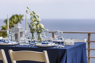 Blue and Silver Romantic Wedding Table Top Layout Table Spread no people catering, event, decor in a tropical location with the sea and clouds in the background