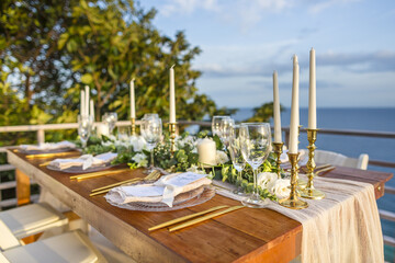 Romantic Wedding Table Top Layout Table Spread no people tropical location with gold cutlery and scenic sea view with copy space
