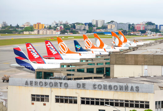 Congonhas Airport (CGH) in Sao Paulo, Brazil with multiple Brazilian airlines aircraft tails lined up. Busy airport terminal with domestic air travel.