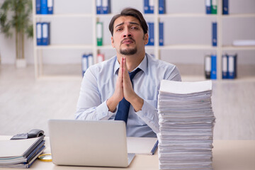 Young businessman employee unhappy with excessive work in the of