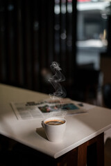 White coffee mug on the table inside the cafe