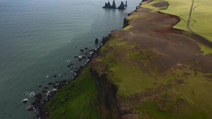 Aerial footage beautiful green cliff coast with basalt rock formation Iceland.