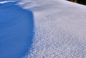 Texture of a snow surface with areas of shadow and light