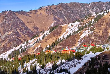 Row of colored houses in a mountain valley in the end of winter season