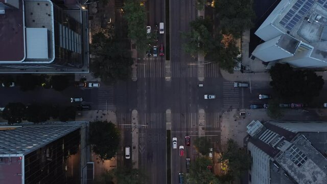 Aerial birds eye overhead top down view of traffic on crossroad. Zooming out evening view of cars driving on street. Mexico city, Mexico.