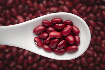 macro Close-up of Organic Rajma,  (Laal Lobia ) or red kidney beans dal on a white ceramic soup spoon in a blurred background. Top view
