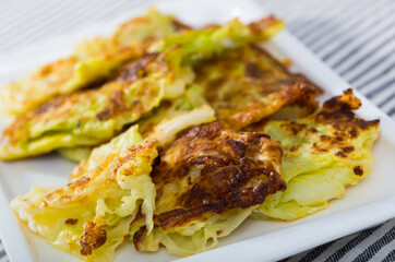 Image of tasty leaves of cabbage in batter on a plate at table