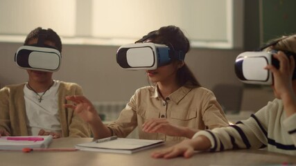 Surprised schoolchildren using 3d vr glasses at lesson in elementary school